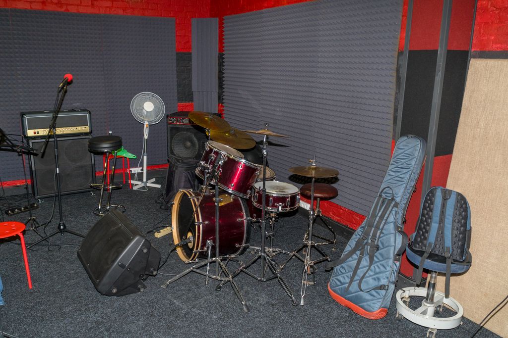 View of the rehearsal room, speakers, drums and guitar in the case