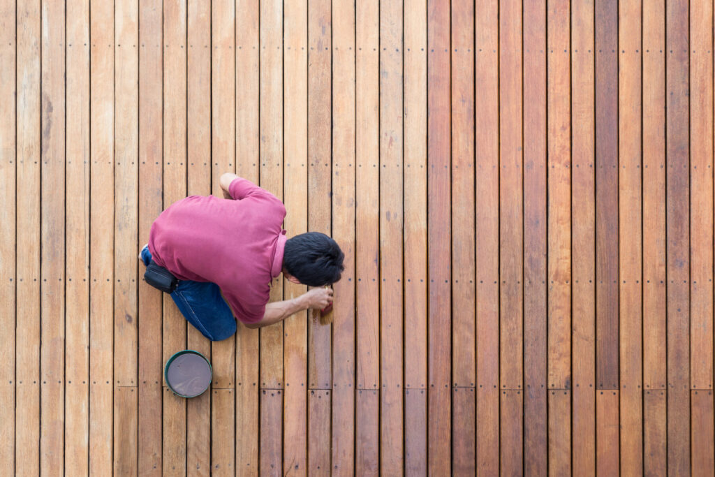 Man working on deck staining