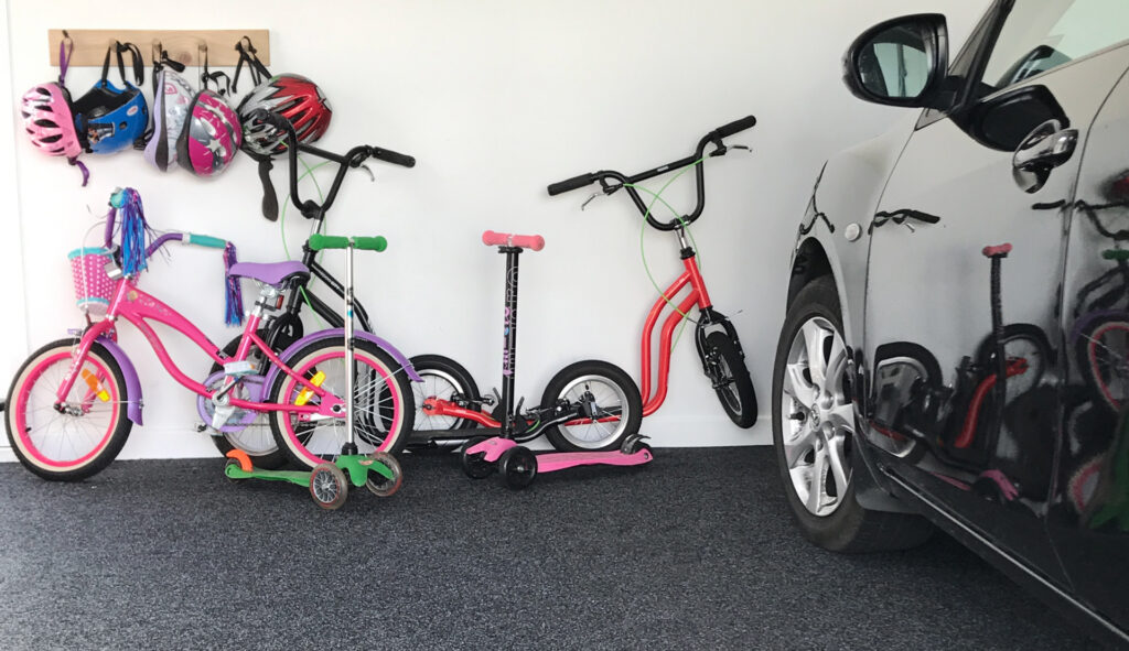 Carpeted garage with kids bikes against wall