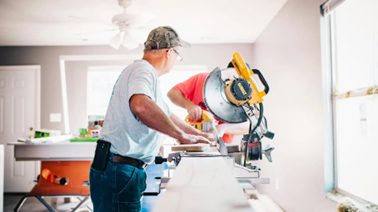 DIY myths debunked - Two men cutting wood in a living room